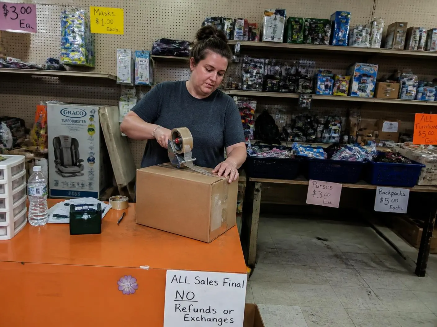 Reseller sorting liquidation merchandise into resale lots Reseller standing in their discount store stocked from liquidation pallets
